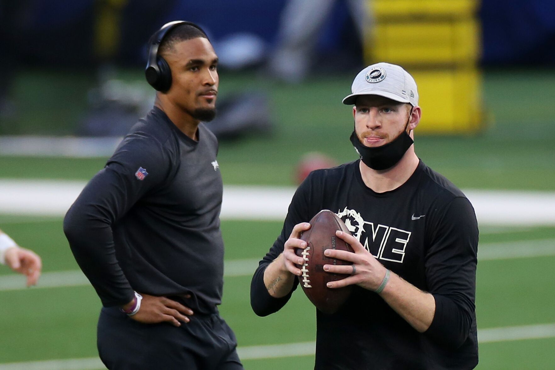 Eagles quarterbacks Jalen Hurts and Carson Wentz warm up before a game against the Dallas Cowboys in December.